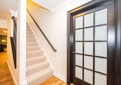 odern basement entry in Oakton, VA with a renovated staircase and bold black door.